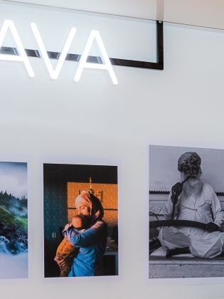 Tavlor uppsatta på en vägg samt en skylt där det står Lava. 