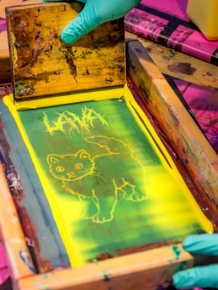 En person jobbar med screentryck. 