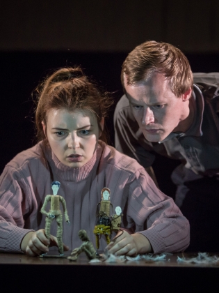 En man och en kvinna vid ett bord med små miniatyrfigurer på. 