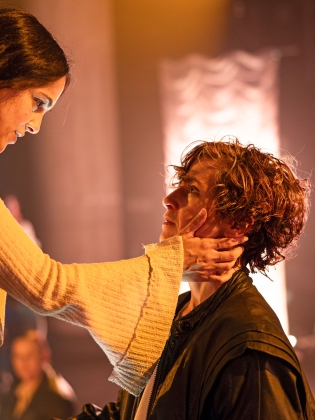 Två personer på scen, den ena håller sina händer mot den andres kind. 