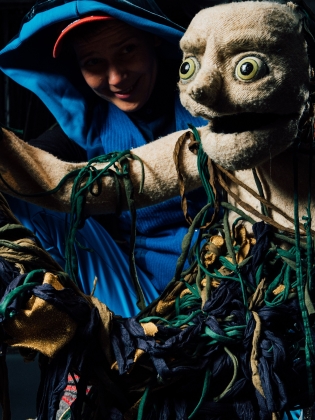 En dockskådespelare håller i en docka. 