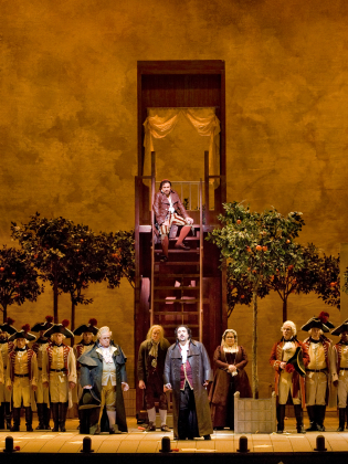 En grupp operasångare i 1700-talskostymer framträder på en scen