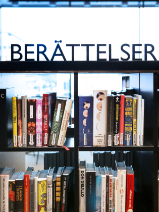 En bokhylla med böcker i på ett bibliotek. 