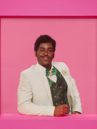 En man står i ett rosa fönster i en rosa vägg.