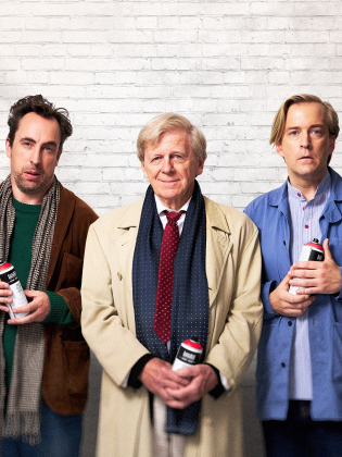 Tre personer poserar mot en vit tegelvägg, alla håller i sprayburkar.