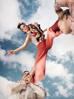 Axel Ahl och Lisa Angberg lyfter upp Sara Runsten i varsin fot mot en blå himmel