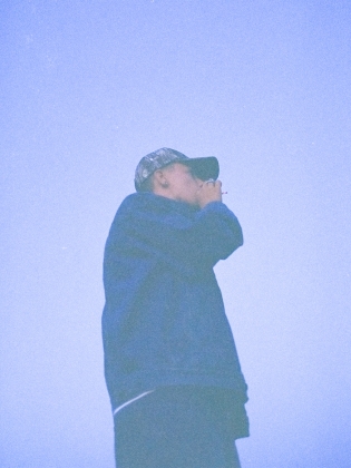 En man i keps fotad i blått ljus