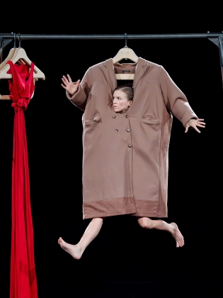 Akrobat som hänger på klädställning