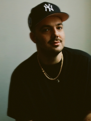 En man med keps ler in i kameran