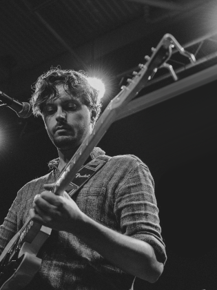 Svartvit bild på man med gitarr