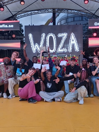 Festivaldeltagare samlade framför en scen.