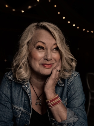 Bilden föreställer en blond kvinna i jeansjacka