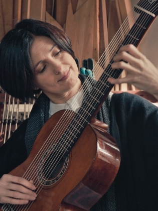 En kvinna spelar på en klassisk gitarr
