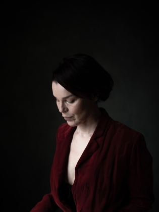 En mörkhårig kvinna i mörkröd blus