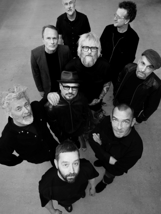 Ett svittvitt foto taget ovanifrån på nio svartklädda män