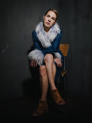 En kvinna i pälskrage på en stol