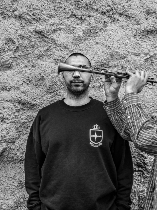 Svartvitt foto på man med en trumpet framför ögonen