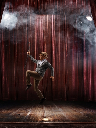 En man i siluett på en scen med en röd ridå