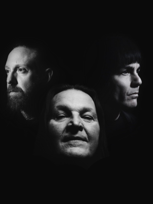 Tre ansikten mot mörk bakgrund