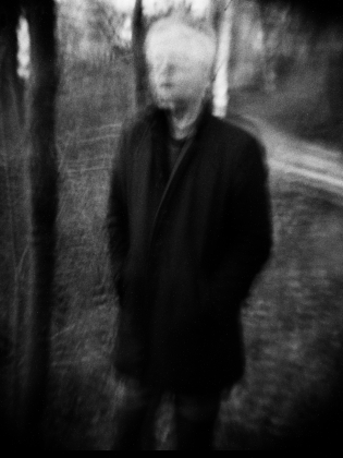 Suddigt svartvitt foto på man i svart rock